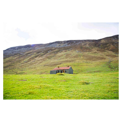 Photograph of an abandoned house in the green hills of a glen in Scotland.
