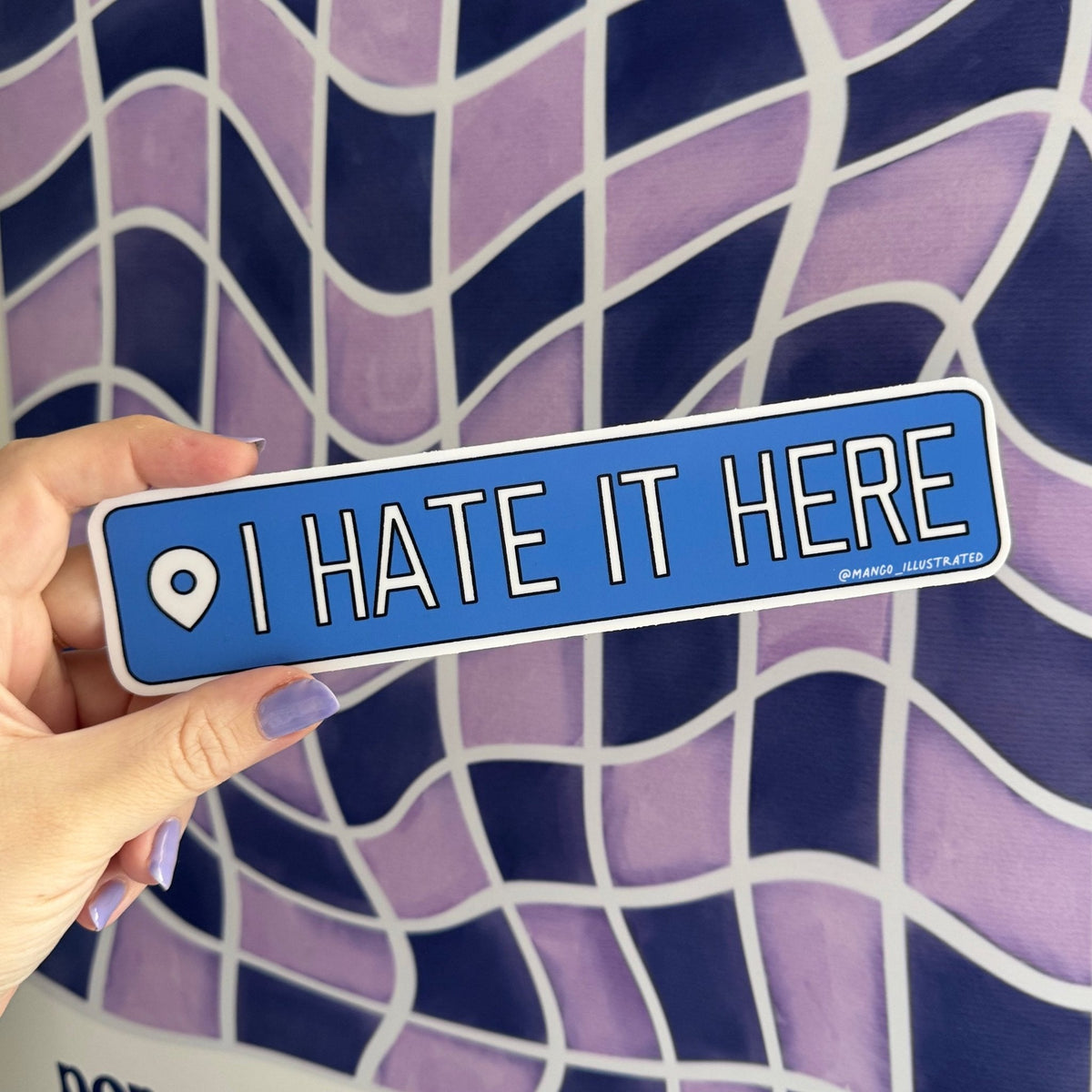 I Hate It Here Bumper sticker flat lay — funny political car decal by indie artist MangoIllustrated