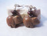 A pair of Carved Stone Pig Earrings featuring small pig-shaped stone pendants on sterling silver leverbacks, accented with round beads and silver spacers, displayed on a white stone background.
