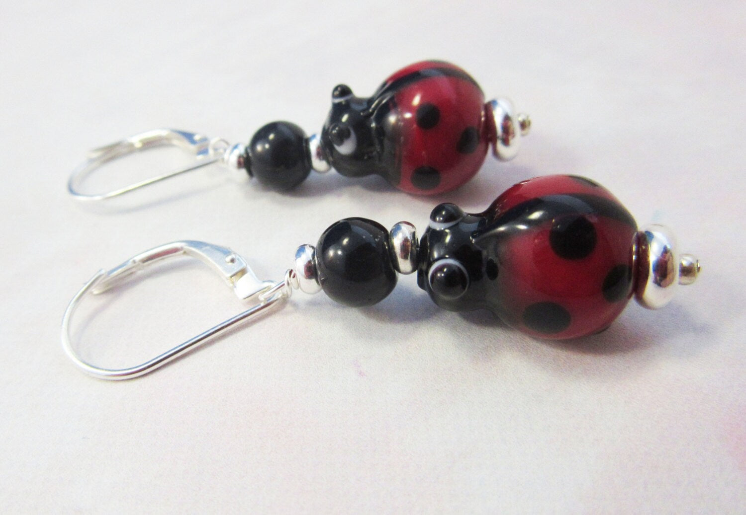 Ladybug earrings of Lampworked Glass featuring vibrant red colors, perfect for insect jewelry lovers and a great gift for gardeners and good luck.