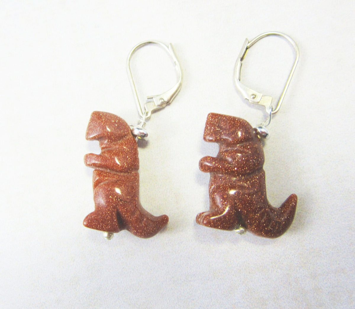 Goldstone Tyrannosaurus rex earrings showcasing a unique and quirky dinosaur motif, great for science and history buffs.