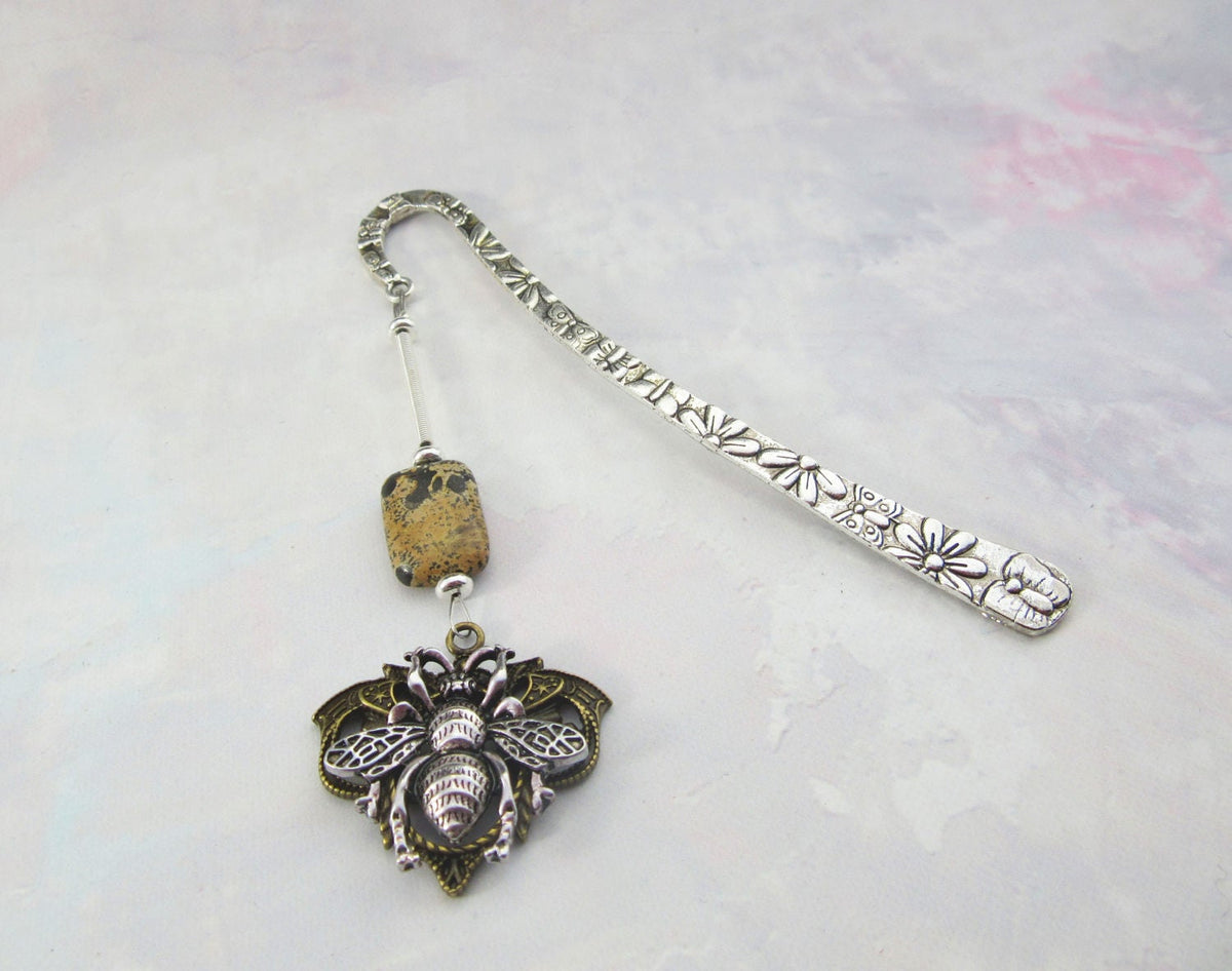 The Handmade Honeybee Bookmark: Bronze &amp; Silver Floral Metal features floral engravings, a speckled bead, and an ornate silver-toned bee pendant—an ideal mindfulness gift for book lovers.