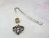 The Handmade Honeybee Bookmark: Bronze & Silver Floral Metal features floral engravings, a speckled bead, and an ornate silver-toned bee pendant—an ideal mindfulness gift for book lovers.