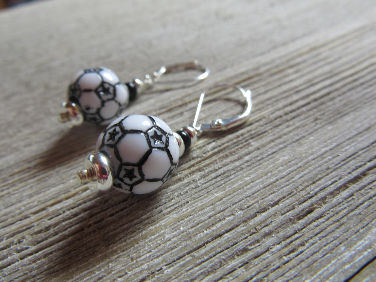 Flat lay of Soccer Ball Earrings showcasing their dangle design - Sports Theme Jewelry - Novelty Women Accessories by Enlivenadorn by Gwynstone.