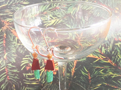 Handmade Christmas Tree Earrings hanging on a jewelry display, ideal for festive occasions.