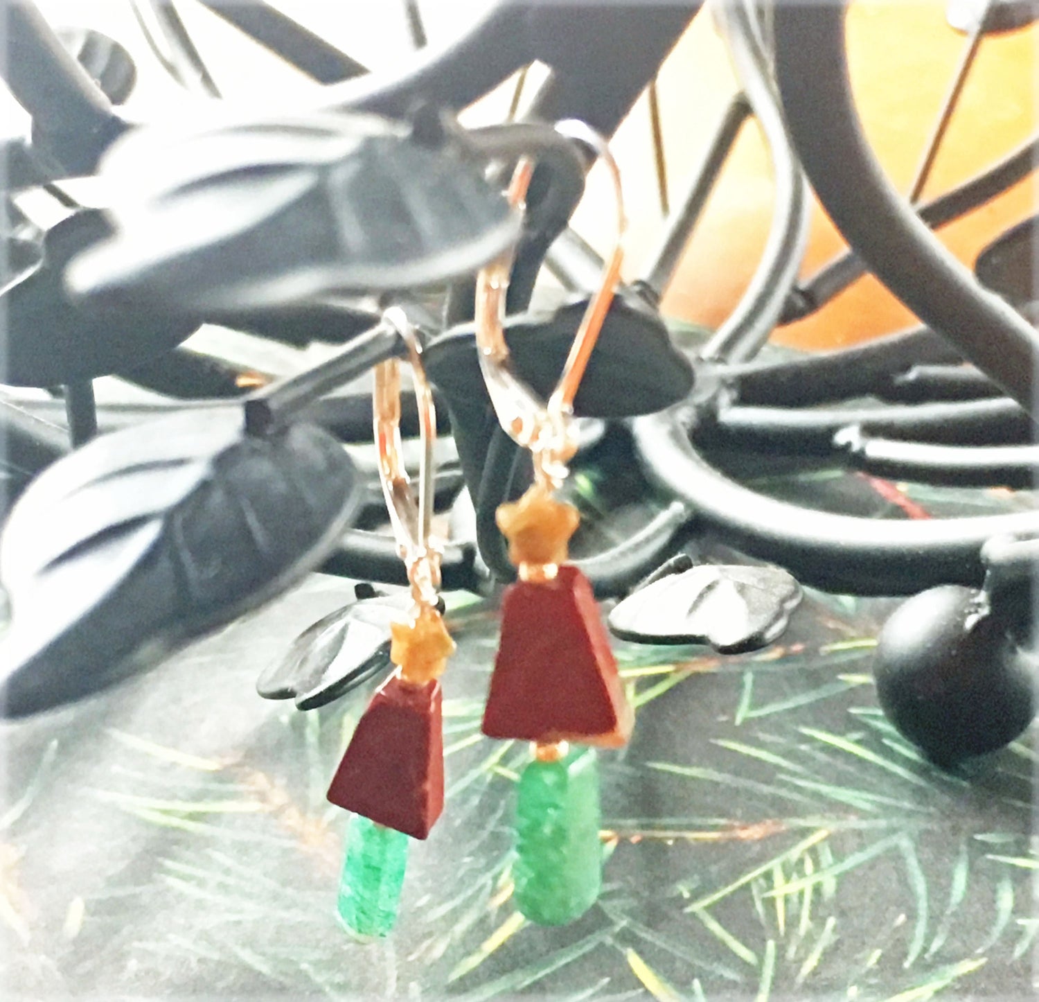 Close-up of Christmas Tree Earrings, showcasing delicate gold star, red jasper tree, and green jasper trunk.