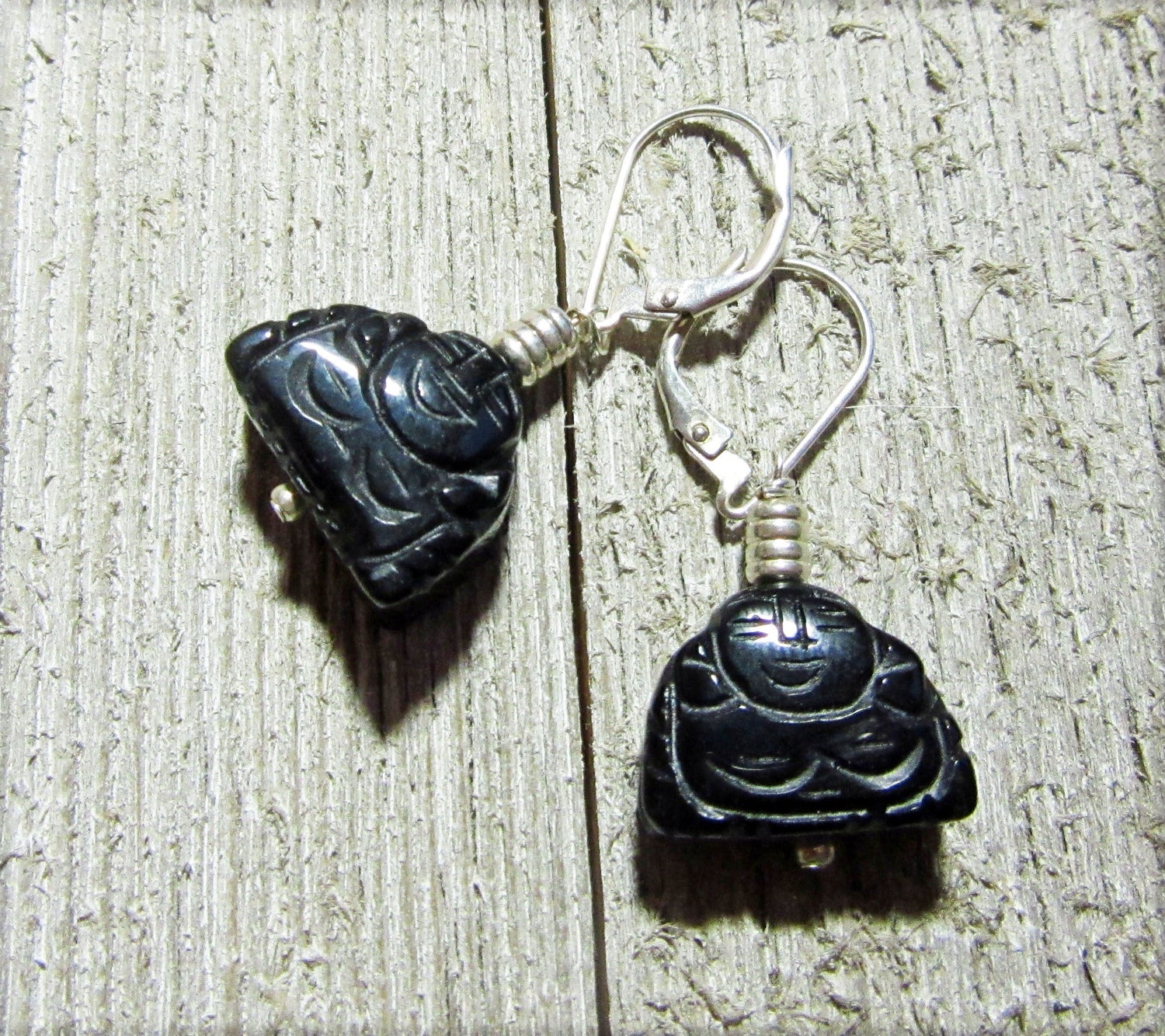 Handcrafted Black Onyx Buddha Earrings: Zen Jewelry Gift with carved Buddha charms and silver hooks, displayed on textured wood—ideal for a tranquil, stylish look.