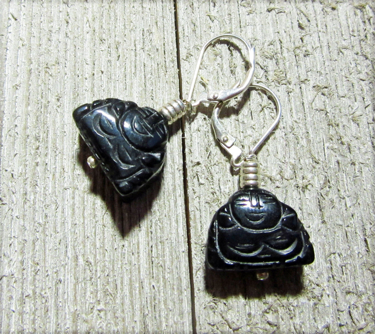 Handcrafted Black Onyx Buddha Earrings: Zen Jewelry Gift with carved Buddha charms and silver hooks, displayed on textured wood—ideal for a tranquil, stylish look.