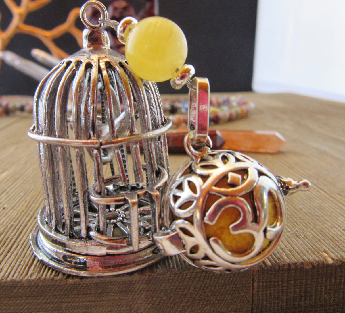 Close-up of the Bird Cage Essential Oil desk sitter showing the yellow bead and OM diffuser chamber; perfect for personal aromatherapy.