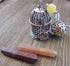 Bird Cage Essential Oil desk sitter showcasing a silver bird and cage design, featuring a yellow bead and OM oil diffuser chamber for aromatherapy self-care with zen aesthetic.
