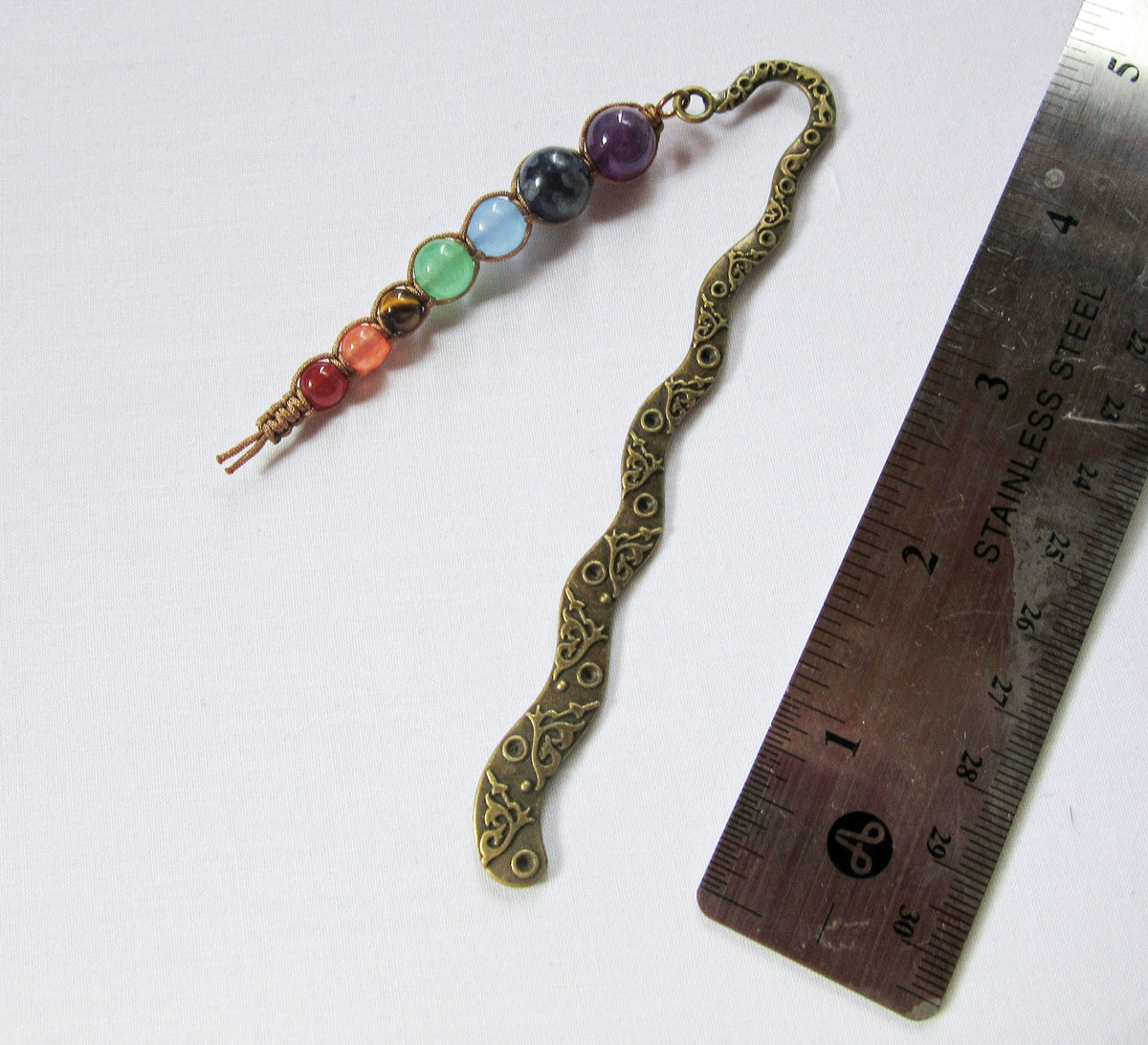 Handcrafted chakra metal bookmark with 7 beads symbolizing root, sacral, solar plexus, heart, throat, third eye, and crown chakras, ideal for book lovers.
