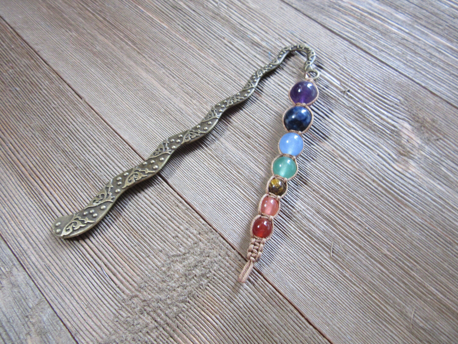 Chakra metal bookmark showcasing the 7 chakras, featuring intricately carved squiggle and chakra end, perfect book gift for spiritual readers.