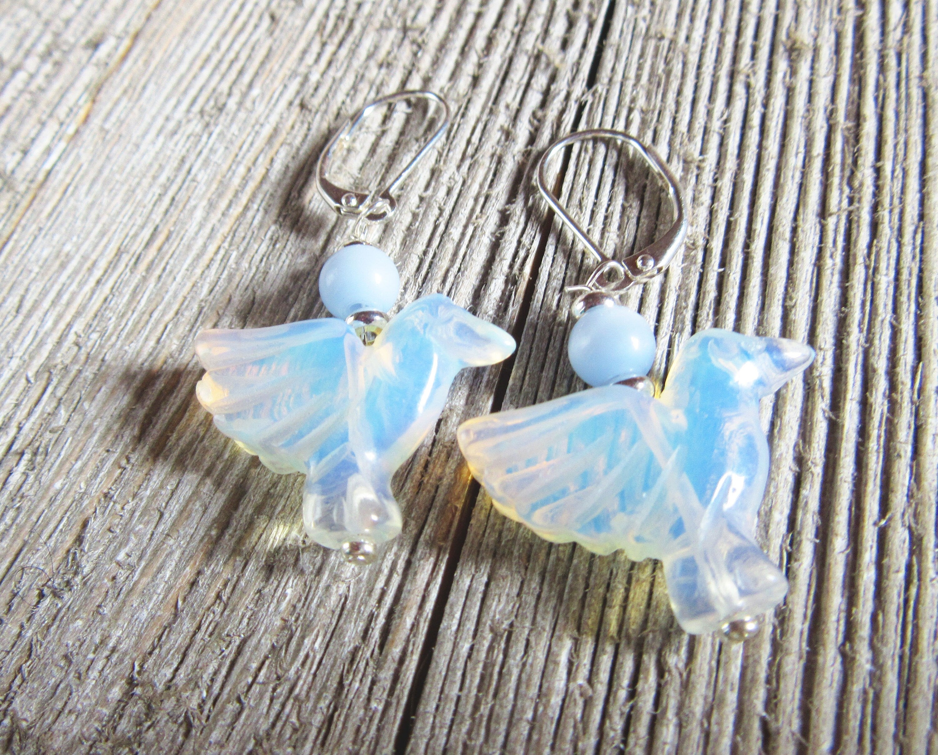 Hummingbird lover earrings made from sodalite and opalite, featuring carved bird designs, a perfect gift for bird lovers and moms, symbolizing hope and jubilation, handcrafted by Enlivenadorn by Gwynstone.