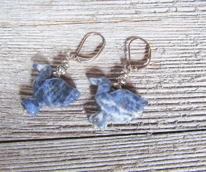 Close-up of carved opalite hummingbird earrings, showcasing intricate details and boho style.