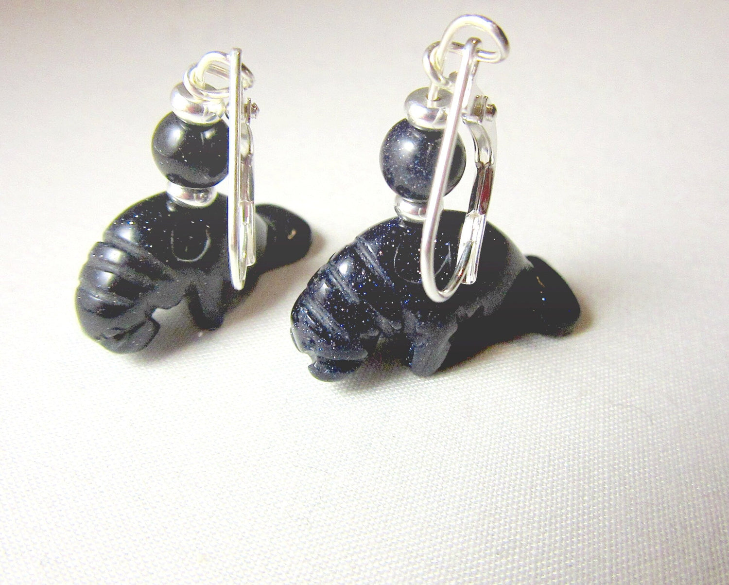 Artisan-made Manatee Earrings displayed elegantly, highlighting the unique carved animal design perfect for sea life enthusiasts.