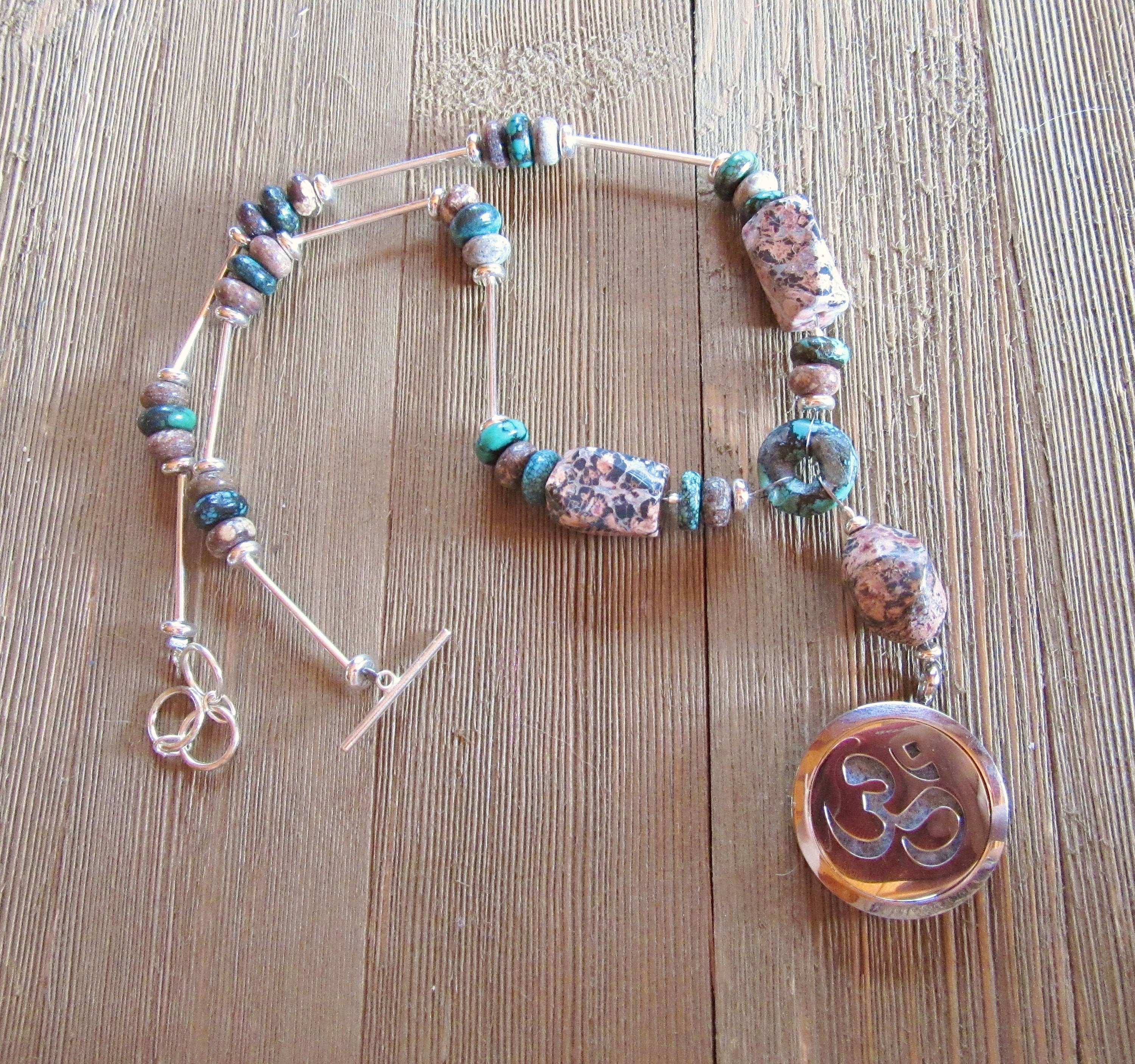 Artisan design of a 22-inch rhodochrosite and turquoise essential oil diffuser necklace with a sterling silver clasp, perfect for aromatherapy.