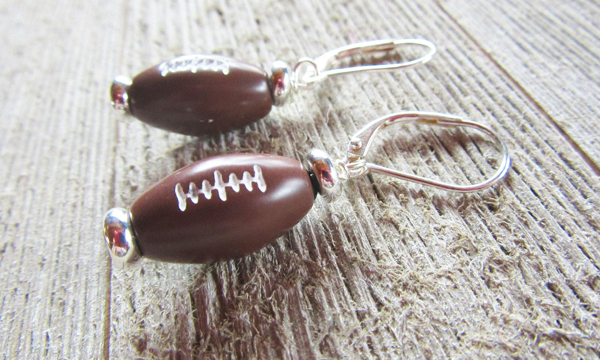 Close-up of Football Novelty Earrings, perfect sports-themed gift for football fans, featuring secure lever back ear wires.