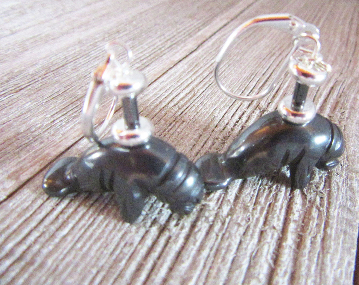 Close-up of Manatee Earrings showing intricate detail of carved hematite black stone, perfect for sea life jewelry enthusiasts.