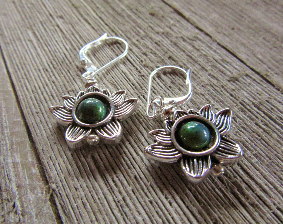 The Lotus Flower Earrings: Mood Bead Zen Jewelry with green stone centers rest on a wooden surface, making an ideal spiritual gift for any occasion.