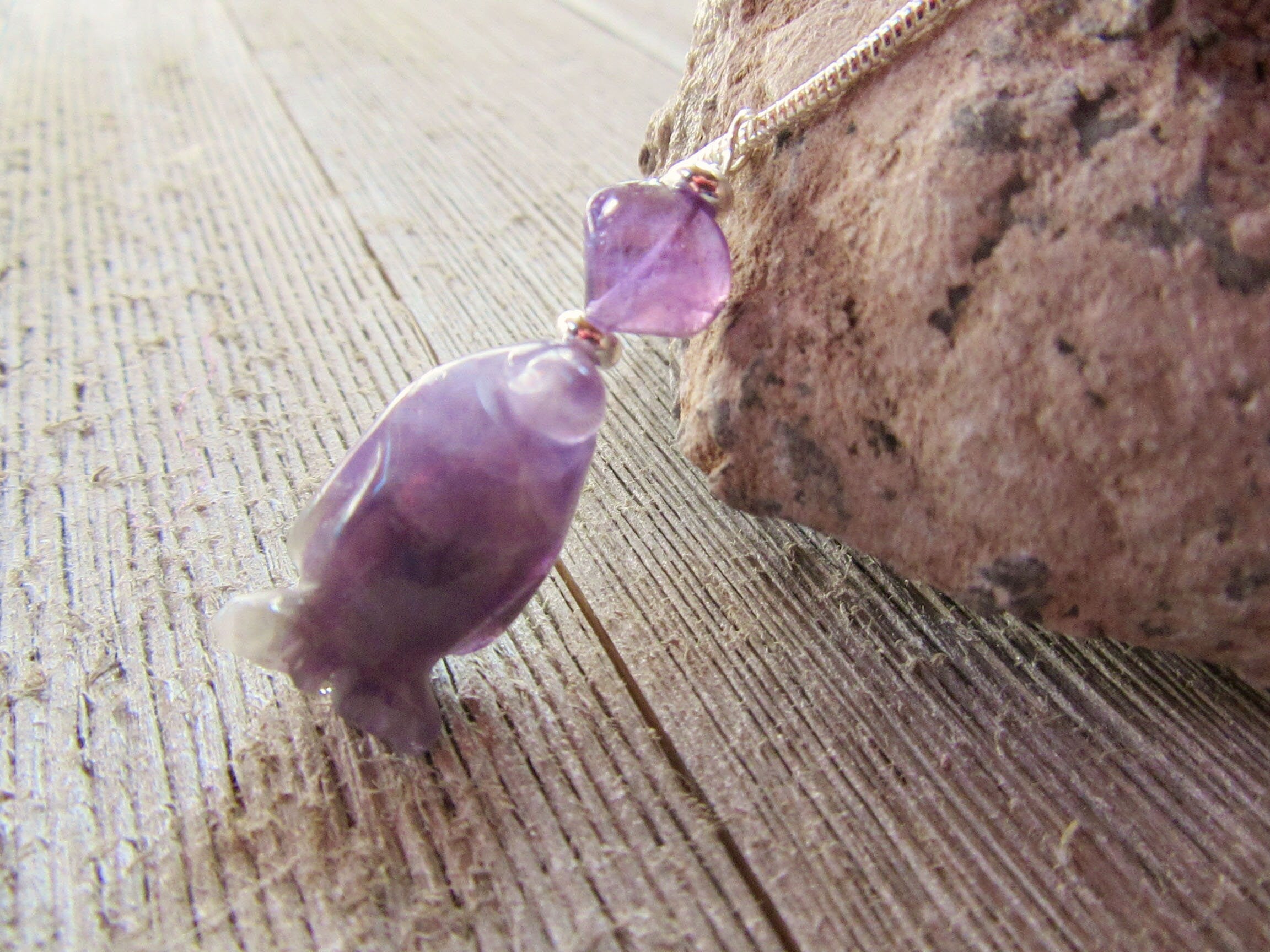 Close-up of purple penguin earrings, part of amethyst jewelry collection, a charming and funny gift for penguin lovers.