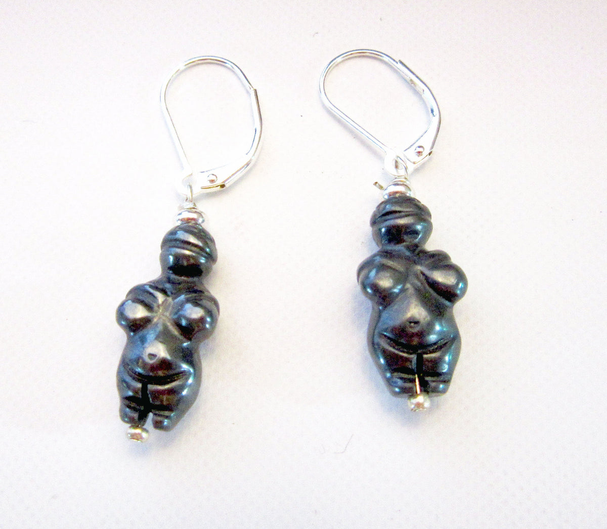 Close-up view of the Goddess earrings inspired by the Venus of Willendorf, showcasing the elegant carved sodalite and primitive style for an ancient soul.
