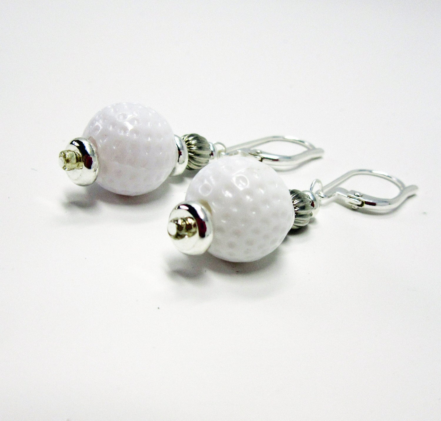 Golf Ball Lever Back Earrings: Novelty Jewelry Gift featuring white golf ball-textured beads with silver accents and secure hooks—an ideal accessory for golf jewelry enthusiasts.