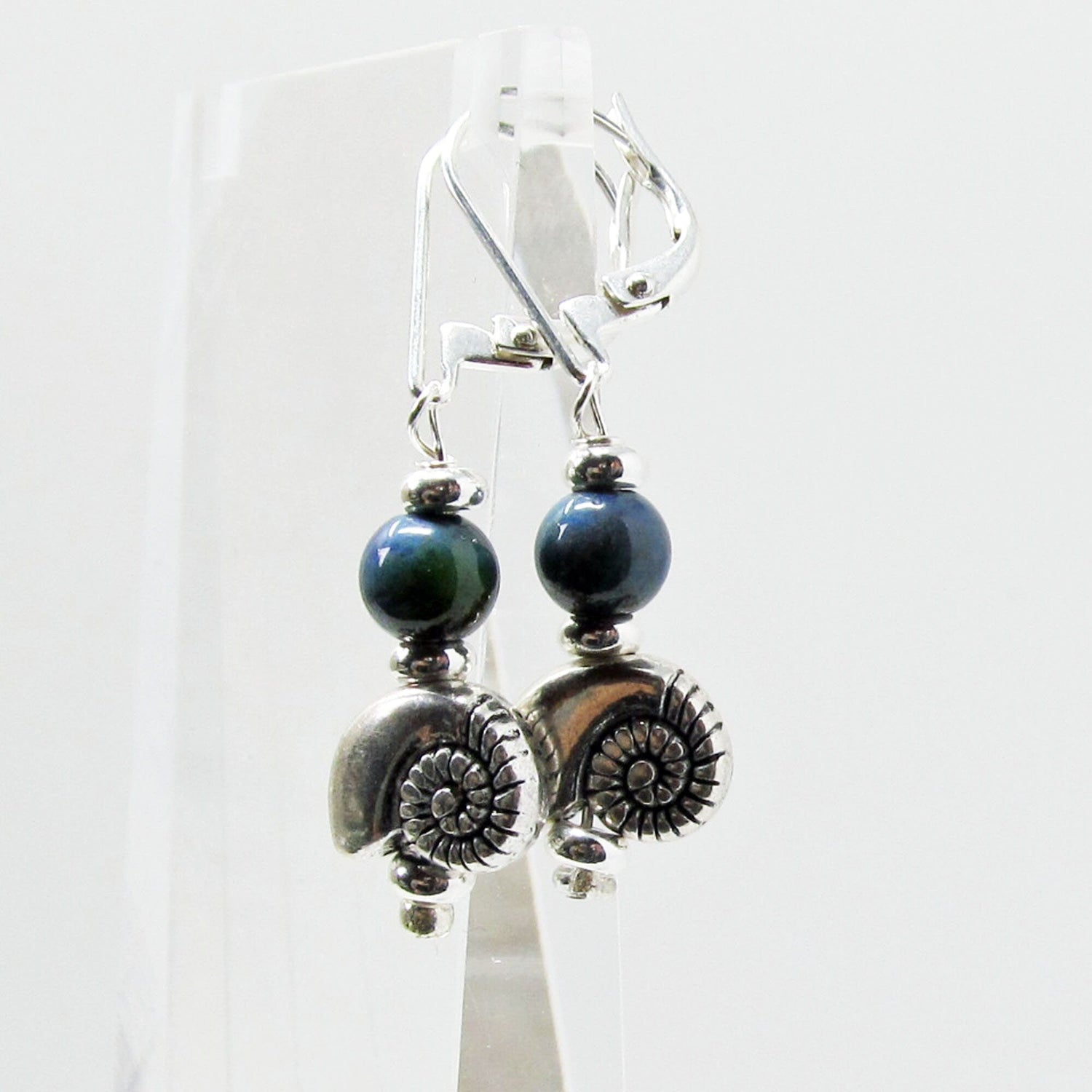 Model wearing SEA SHELL EARRINGS - Silver Shell Earring dangles, highlighting their bohemian style and versatility with various outfits.