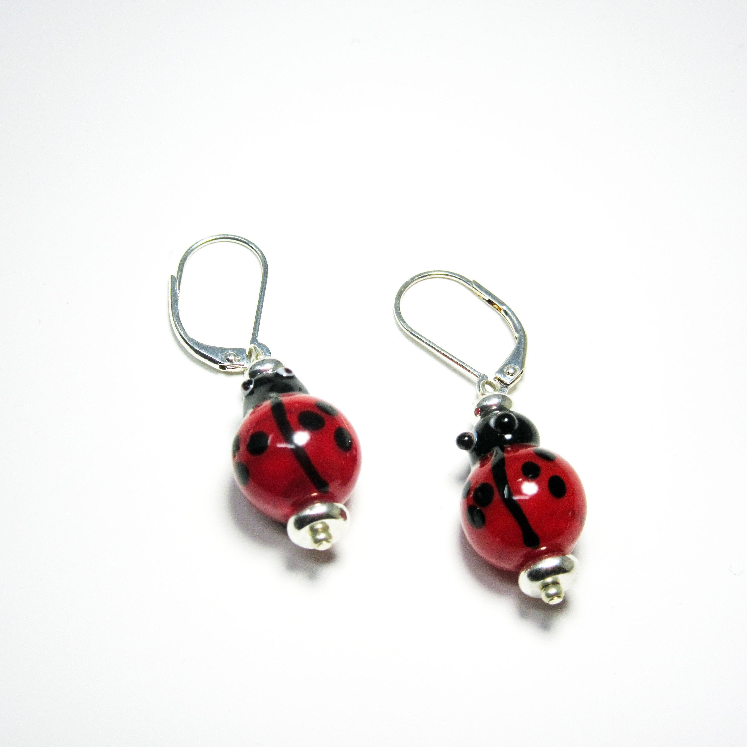 Fun Earrings showcasing unique ladybug designs in lampworked glass, perfect for symbolizing good fortune and love.
