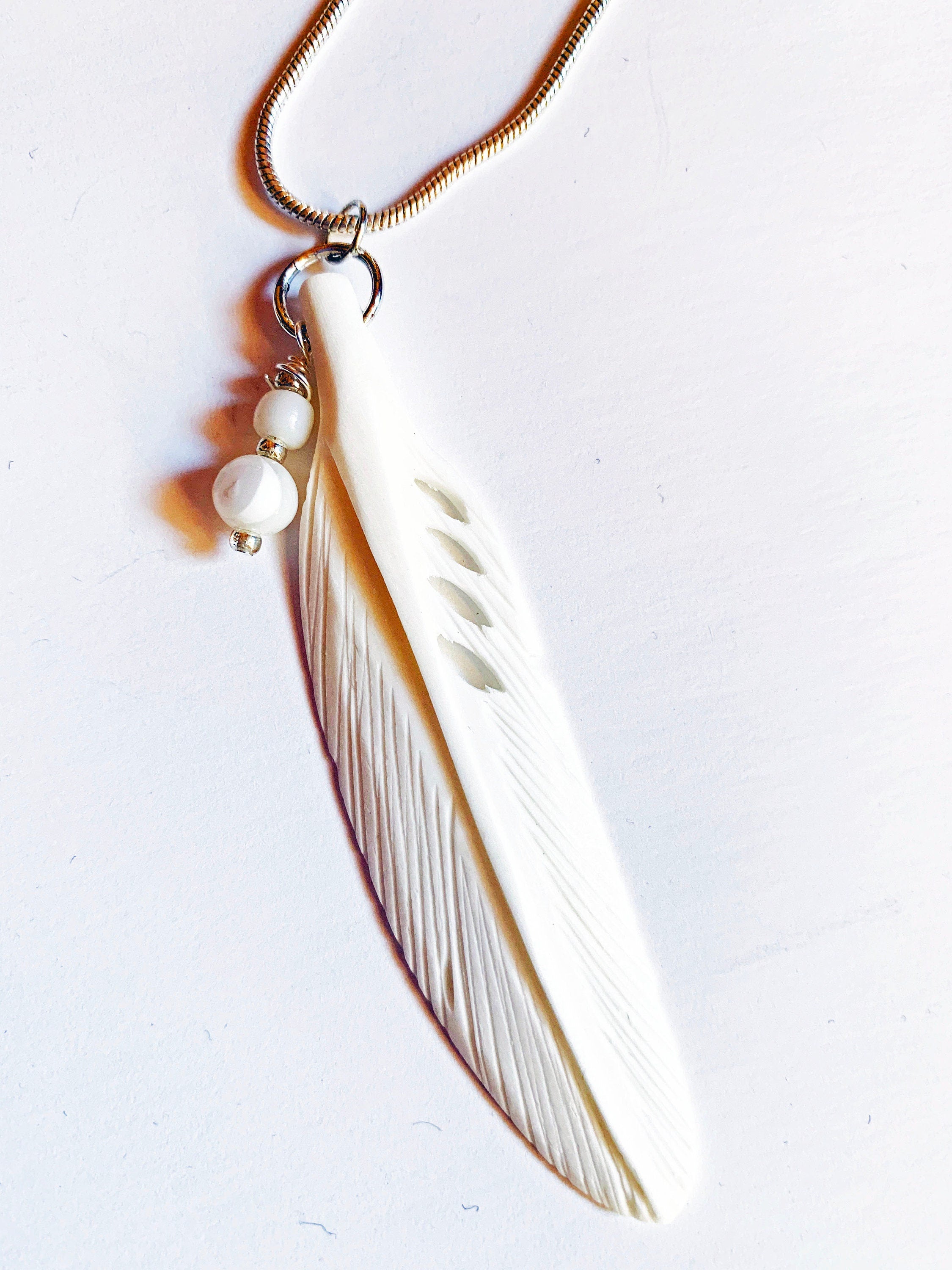 Close-up of the White Feather Pendant Necklace, showcasing its elegant feather design and white pearls, perfect for gifting.