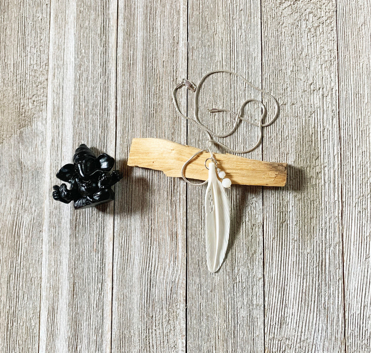 White Feather Necklace from Enlivenadorn by Gwynstone, representing hope and protection, hanging on a delicate snake chain.
