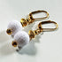 Gold Golf Ball Leverback Earrings: Lightweight handmade jewelry featuring gold-colored hooks, white textured round beads, and decorative gold accents, displayed on a white surface.