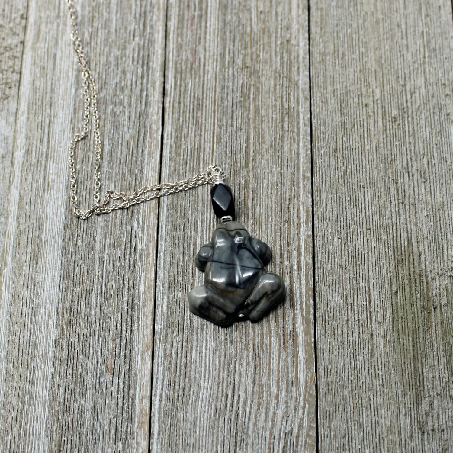 Frog Pendant - Carved Picasso Jasper Frog Jewelry, highlighting the spiritual symbolism of frogs and their metamorphosis.