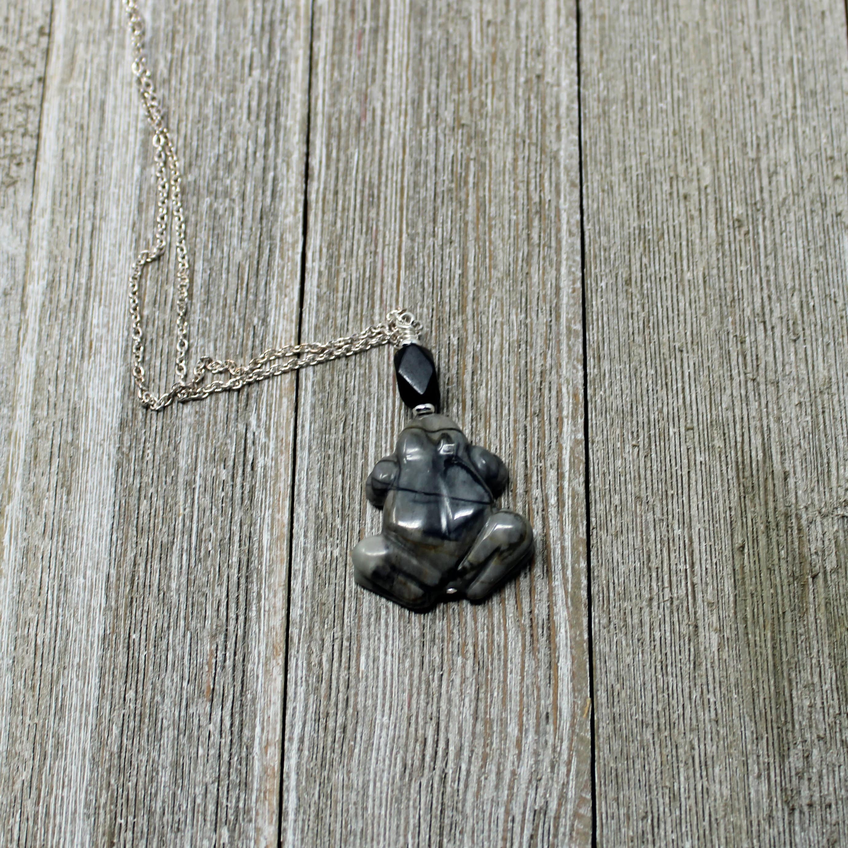Frog Pendant - Carved Picasso Jasper Frog Jewelry, highlighting the spiritual symbolism of frogs and their metamorphosis.