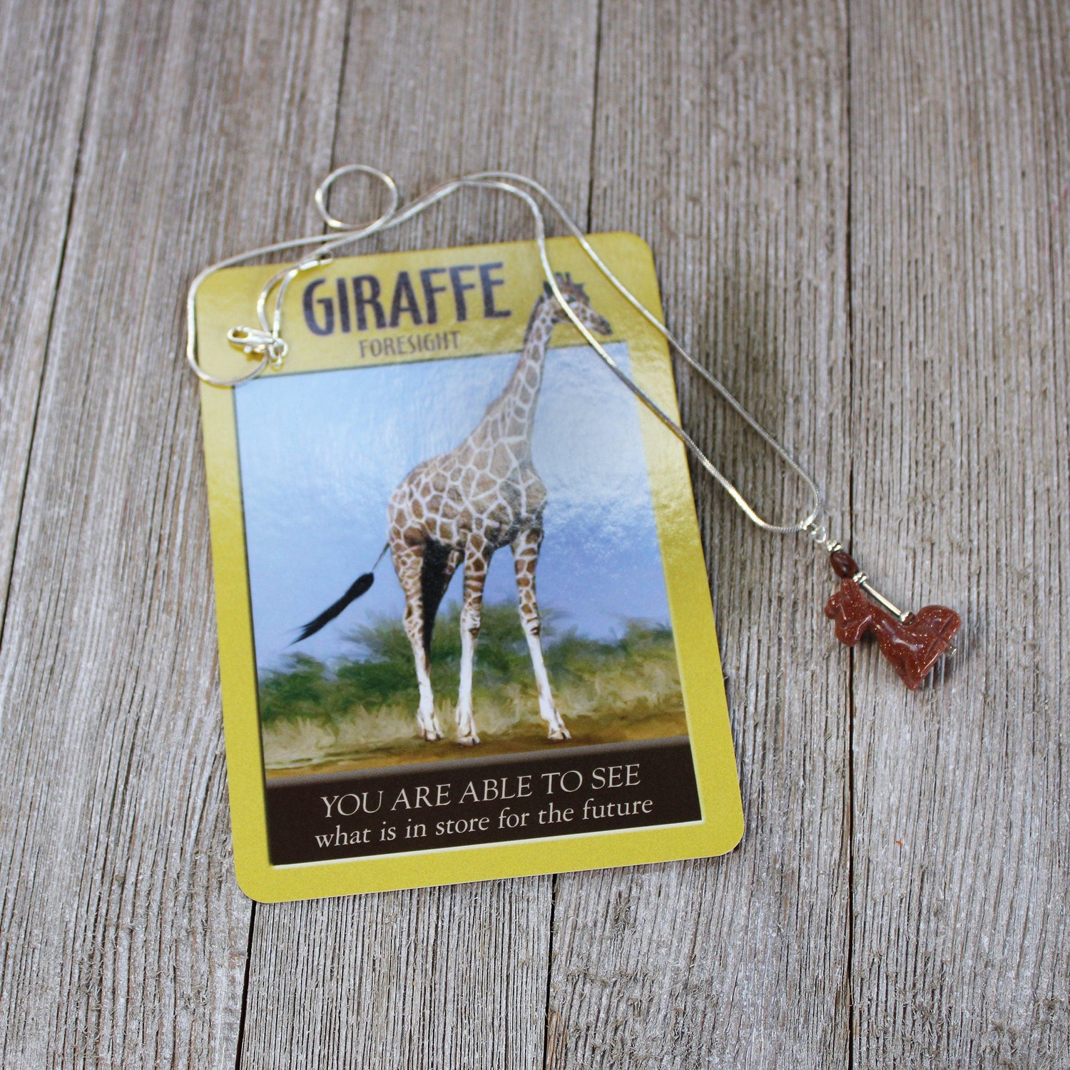 Close-up view of the Giraffe Necklace showcasing the goldstone pendant, ideal gift for animal enthusiasts.
