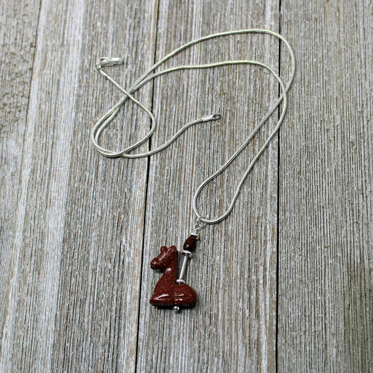Giraffe Necklace on display with an 18-inch chain, a beautiful accessory for animal lovers and those who embrace positivity.