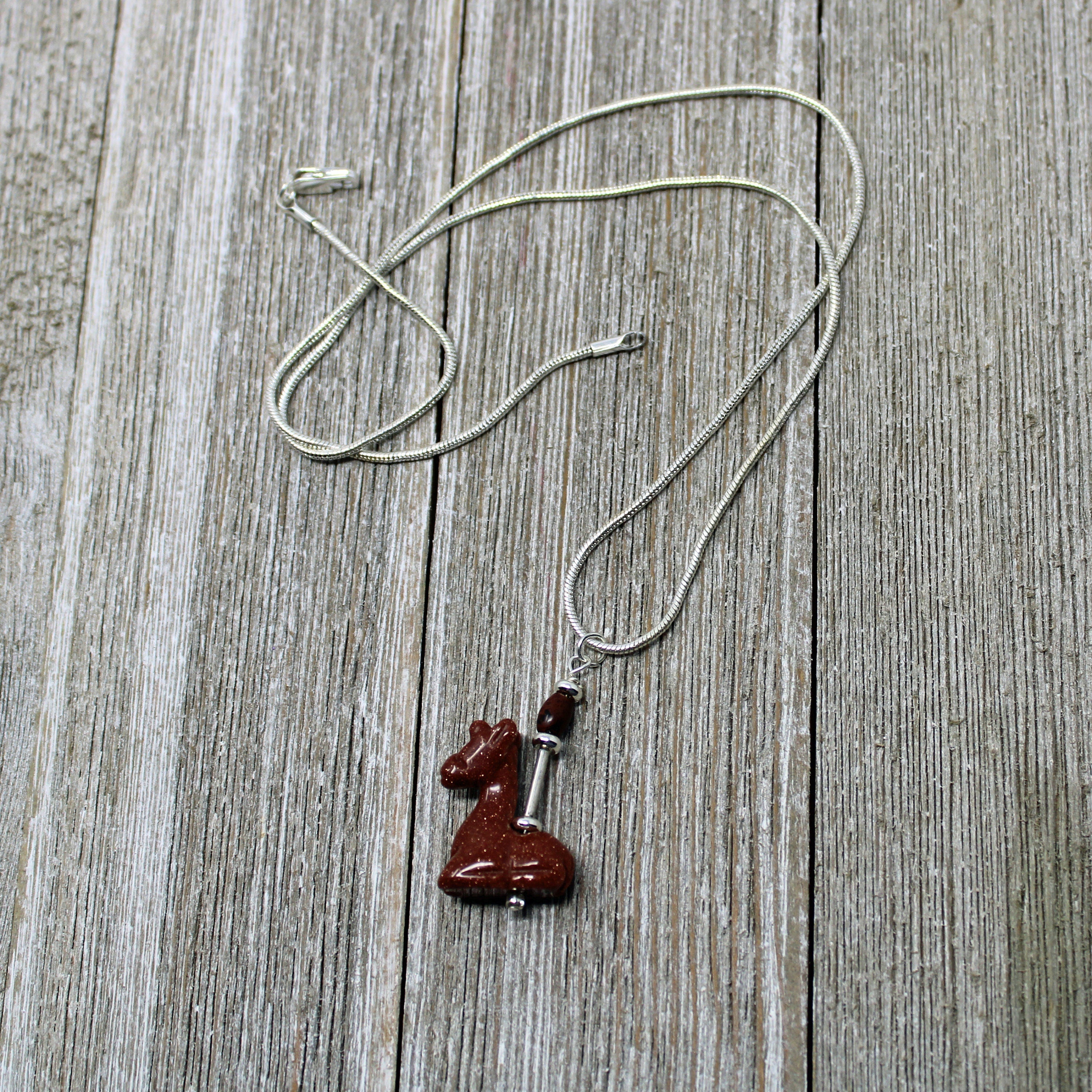 Giraffe Necklace on display with an 18-inch chain, a beautiful accessory for animal lovers and those who embrace positivity.