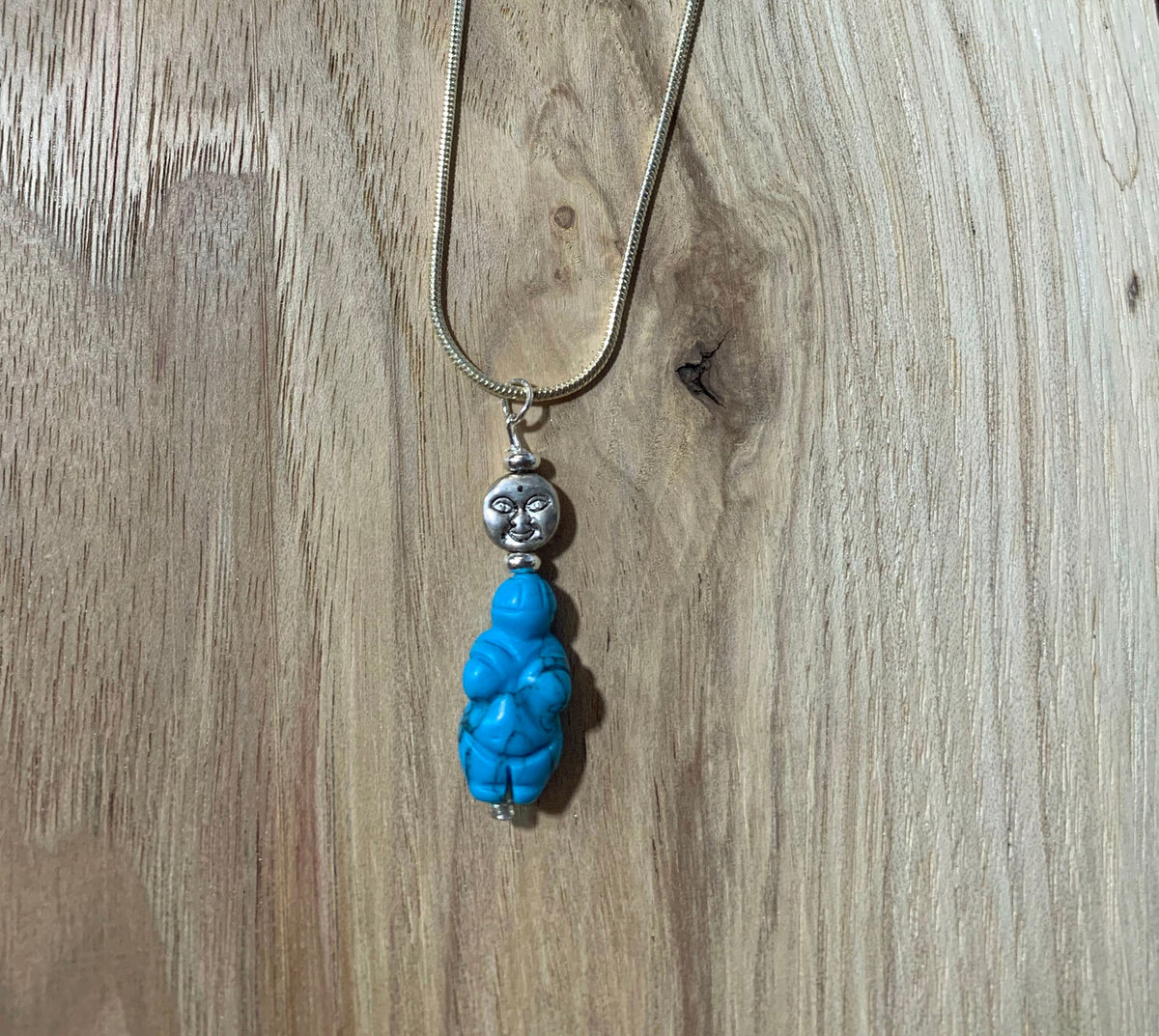 Close-up of Goddess of Willendorf - Moon Priestess Turquoise Pendant showcasing its details, representing woman power and fertility.