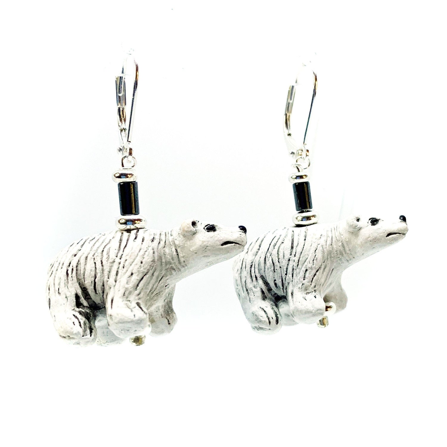 Hand-Painted Polar Bear Ceramic Earrings with Hematite Beads, featuring detailed black and white polar bear figurines on silver hooks, displayed against a white background.