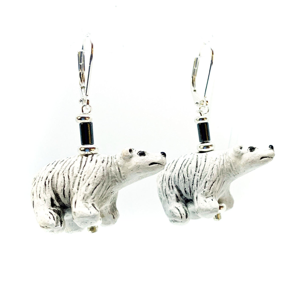 Hand-Painted Polar Bear Ceramic Earrings with Hematite Beads, featuring detailed black and white polar bear figurines on silver hooks, displayed against a white background.