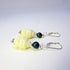 Kwan Yin Sterling Silver Earrings: Carved Stone Compassion Jewelry feature cream Buddha head charms, green round beads, and silver hooks, beautifully displayed on a white surface.