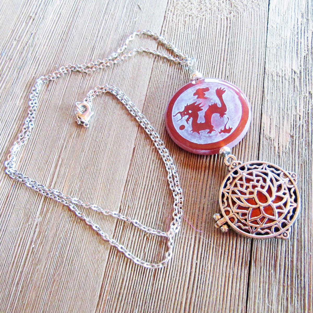 Zen style Peacock and Dragon Etched Carnelian Jewelry on a wooden surface, emphasizing its artisan design.