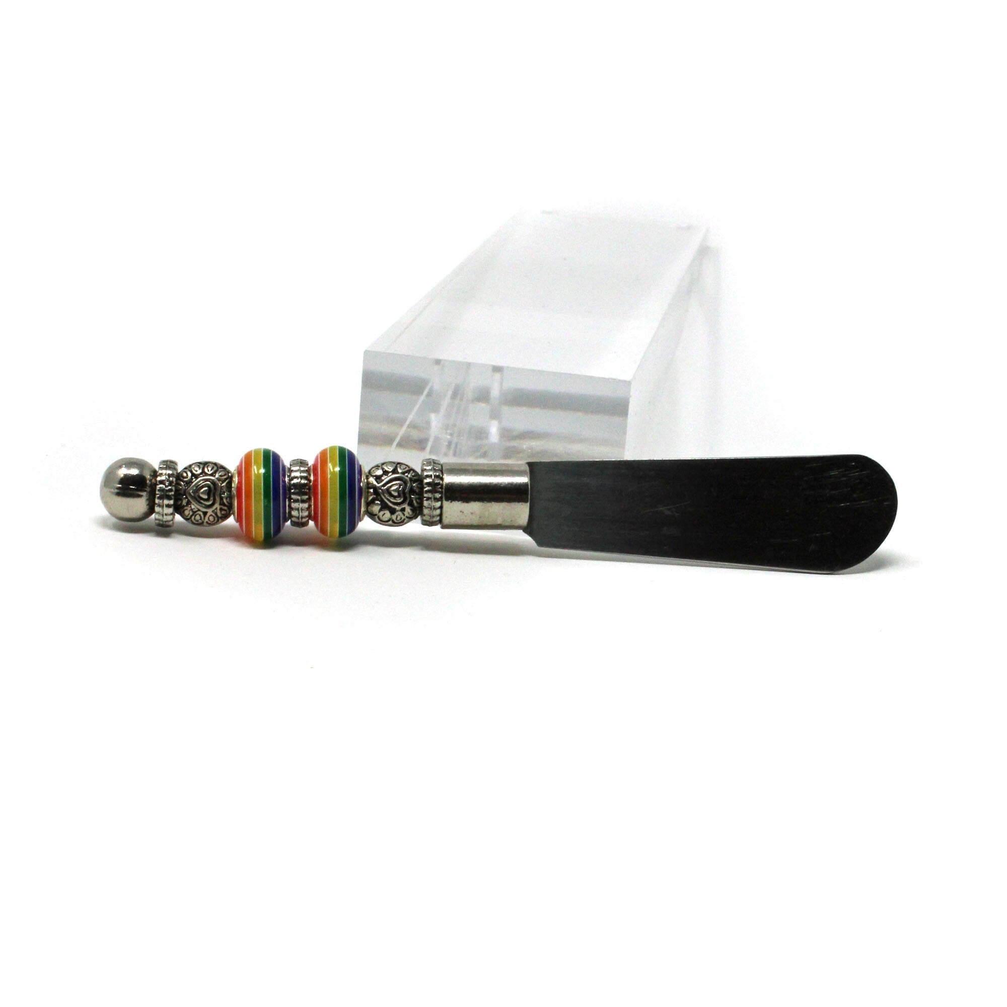 The Rainbow Pride Cheese Spreader Knife features a colorful, handcrafted handle—perfect as a fun kitchen accessory or unique gift for housewarmings and hosts, and ideal for charcuterie boards at any gathering.