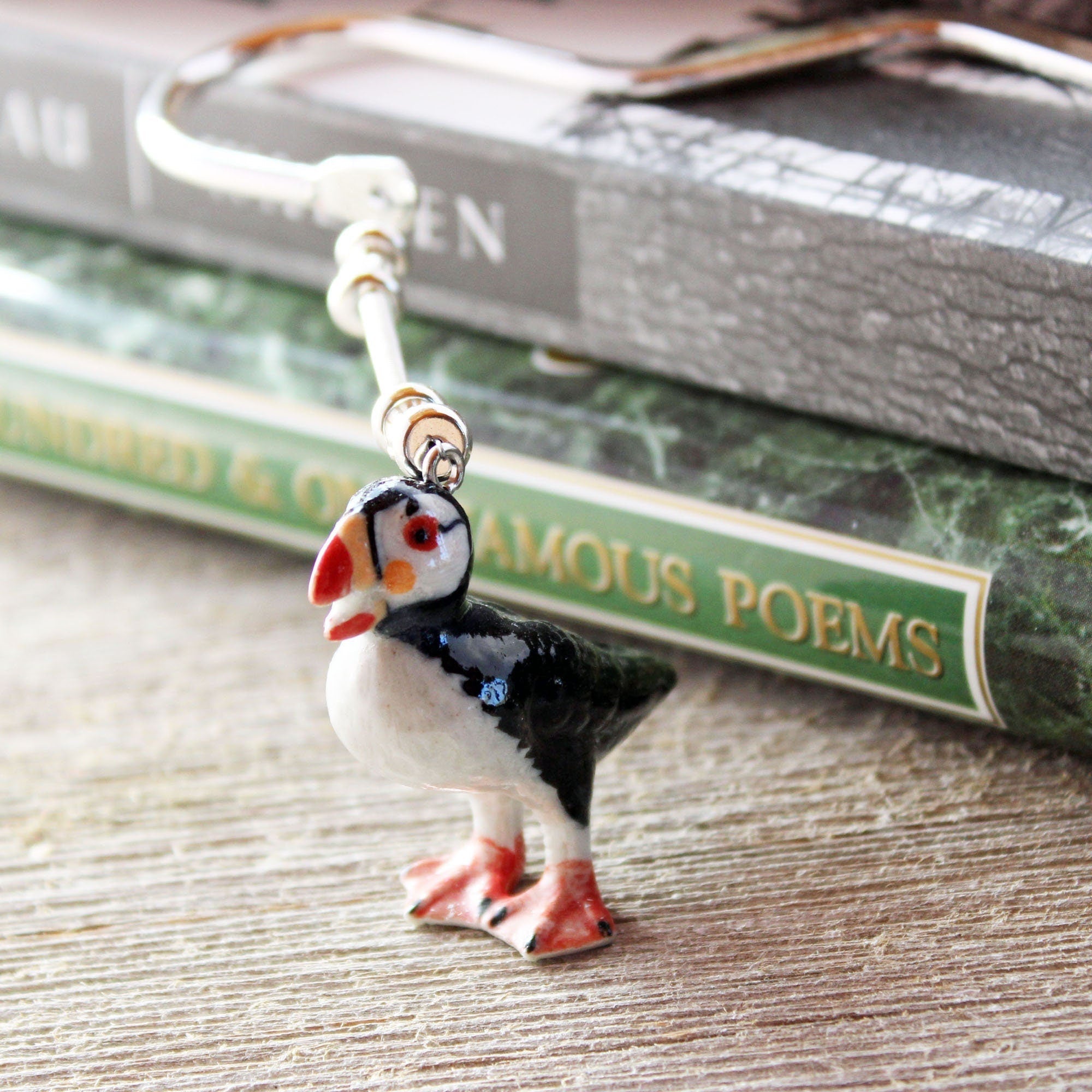 Puffin Bird metal bookmark displayed on an open book, highlighting its functionality as a bookmark for readers and gift option.