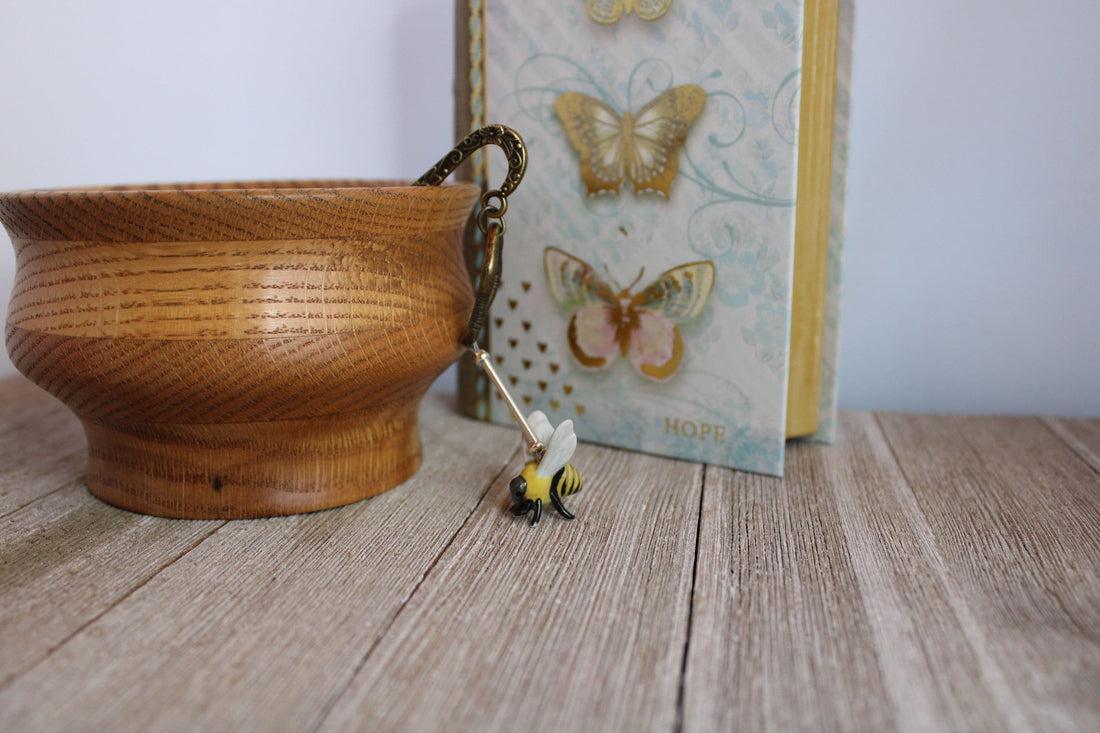 Close-up of the Buzzing Bee Porcelain Bookmark showcasing intricate details of the bronze bee and floral design, ideal for nature enthusiasts.