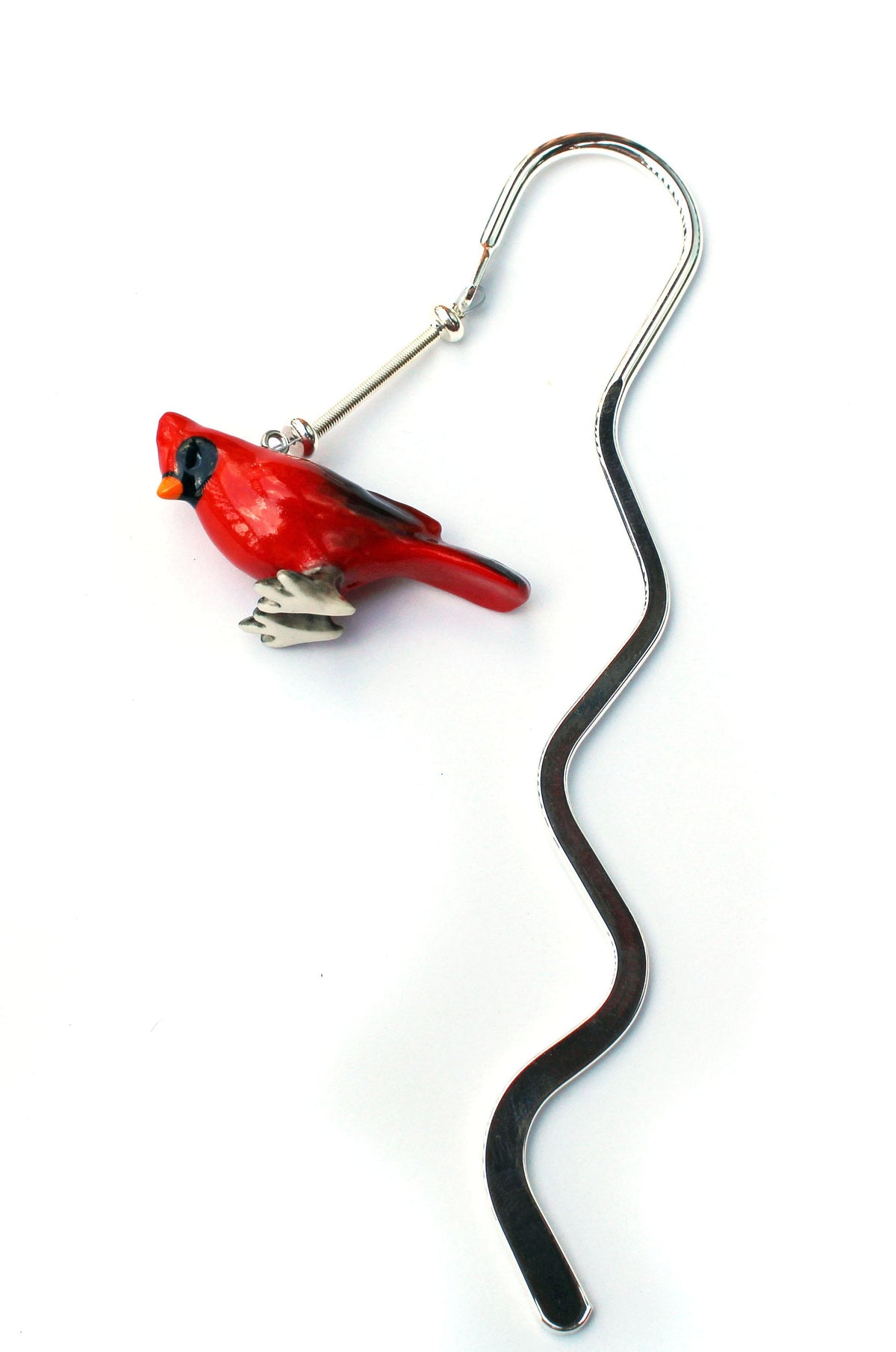 Red Bird Cardinal Bookmark - Songbird Metal Bookmarker displayed with a book, illustrating its use as a charming reading accessory.