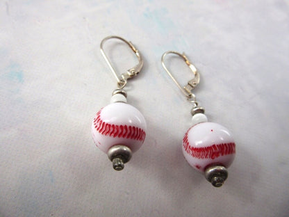 Close-up of baseball novelty earrings - sport gift, showcasing red stitching on a white ball, perfect for coaches and baseball supporters.