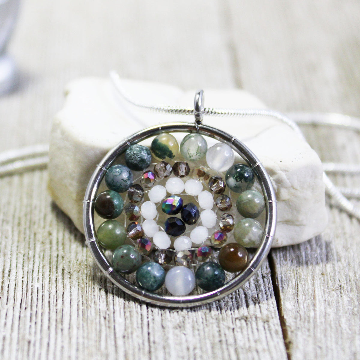 Close-up of the Mandala Pendant necklace showcasing its intricate faceted stone jewelry design with colorful crystals.