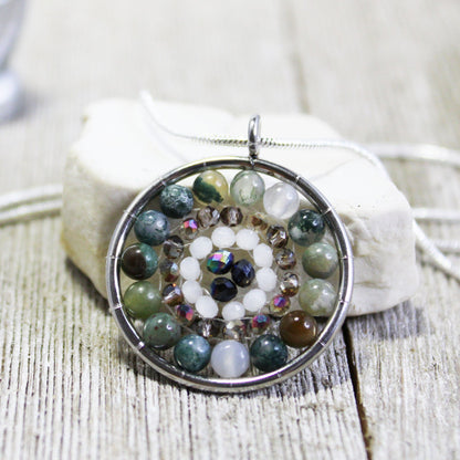 Close-up of the Mandala Pendant necklace showcasing its intricate faceted stone jewelry design with colorful crystals.