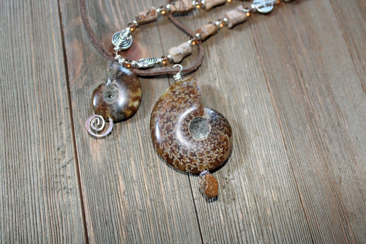 Ammonite fossil partner jewelry necklace set featuring an inch and a half pendant with opalescent bands.