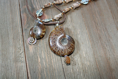 Ammonite fossil partner jewelry necklace set featuring an inch and a half pendant with opalescent bands.